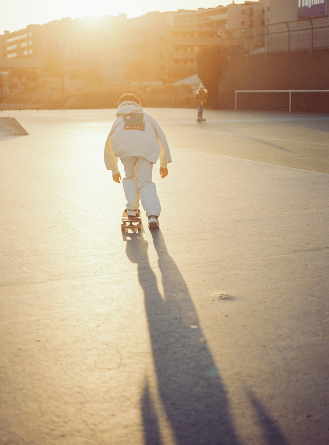 夕日が差し込む中スケートボードの練習をしている。