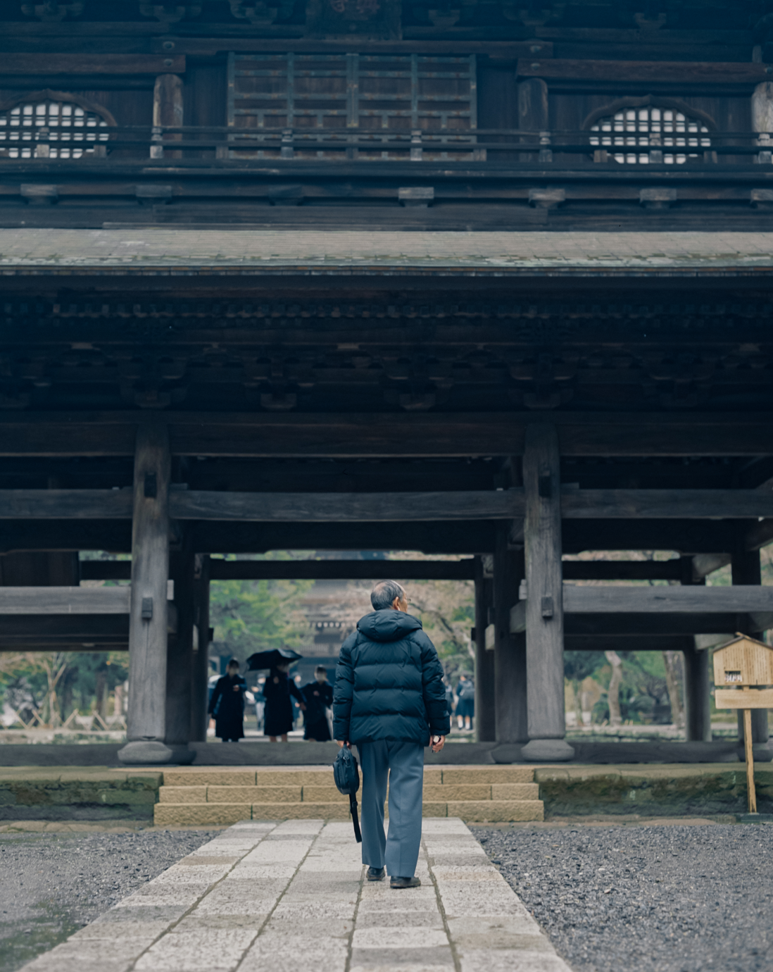 お寺の境内を散策する男性。