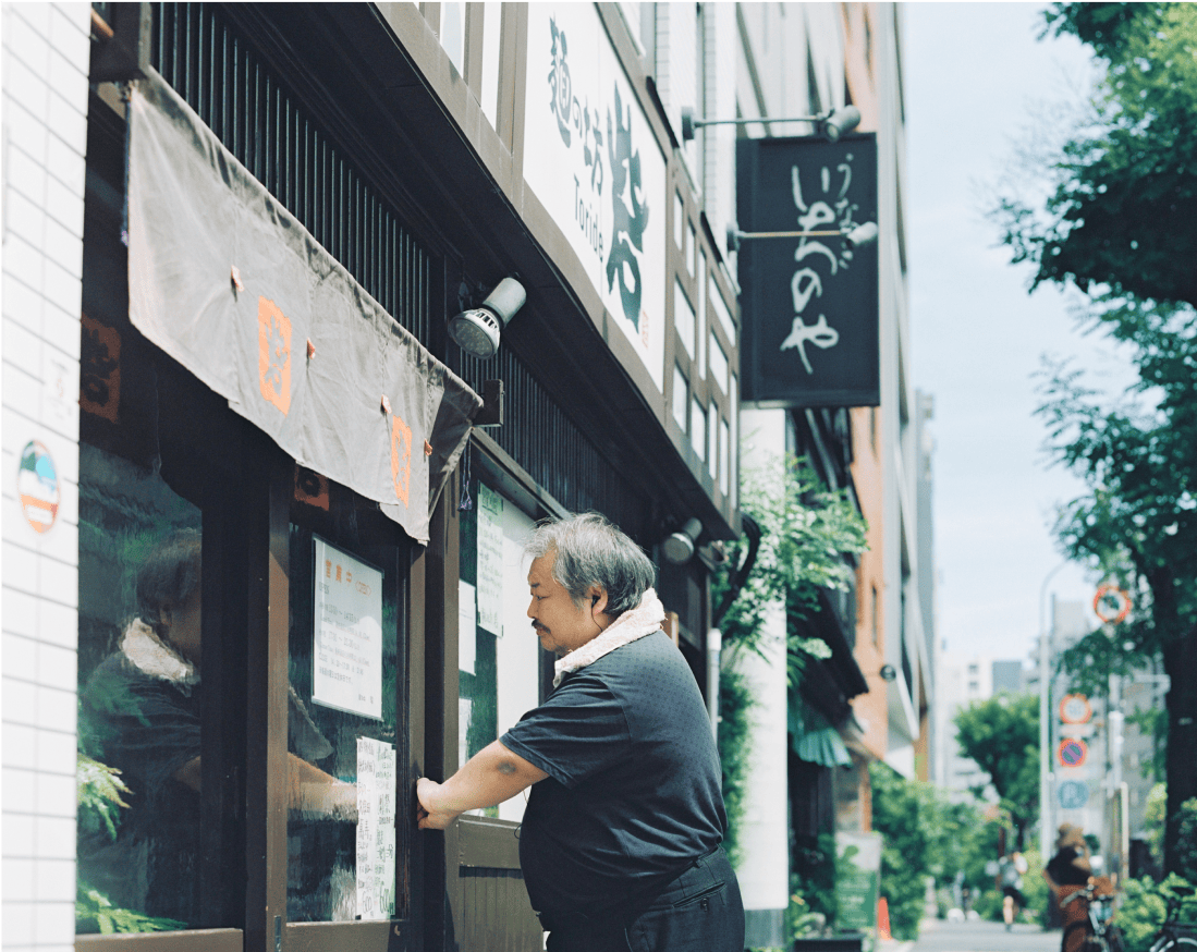 店内に入るために扉を開ける男性。