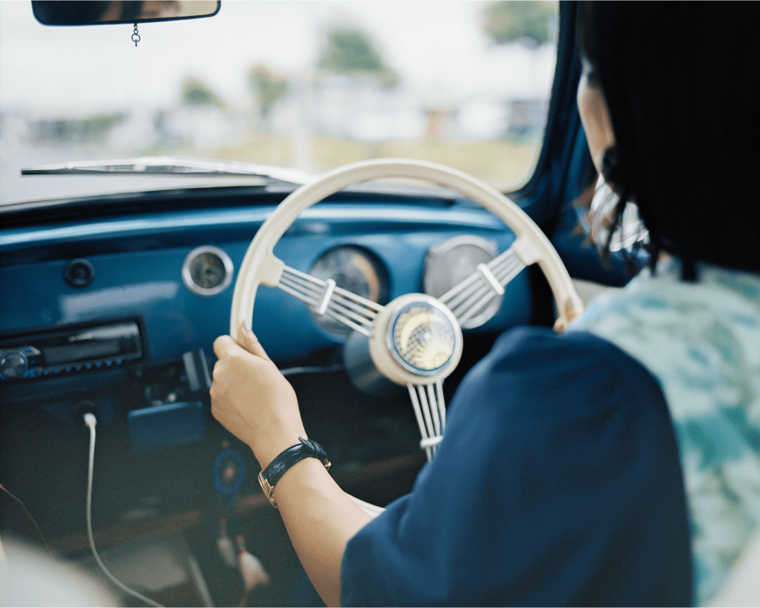 車のハンドルを握っている女性。