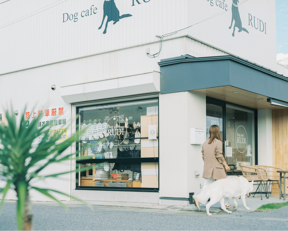 Dog cafe RUDIに入店しようとしている女性と犬。