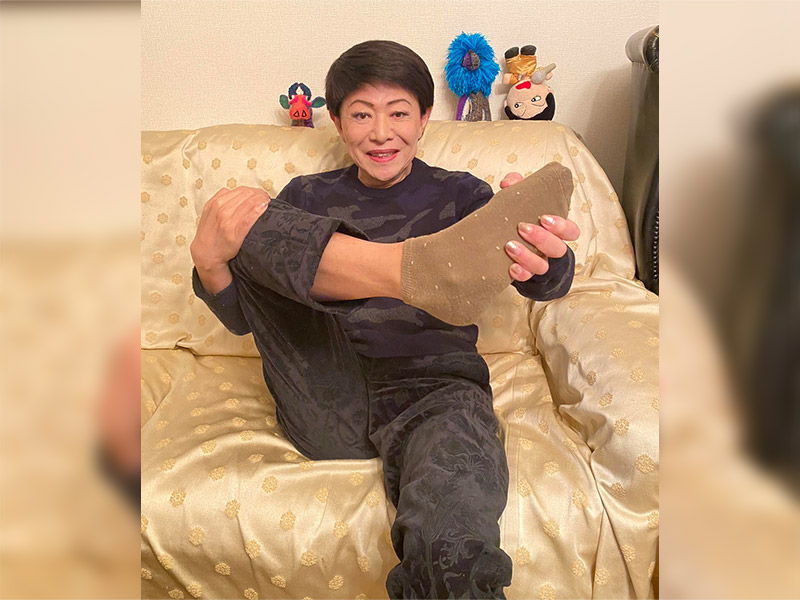 【写真】靴下をはいて見せる美川さん