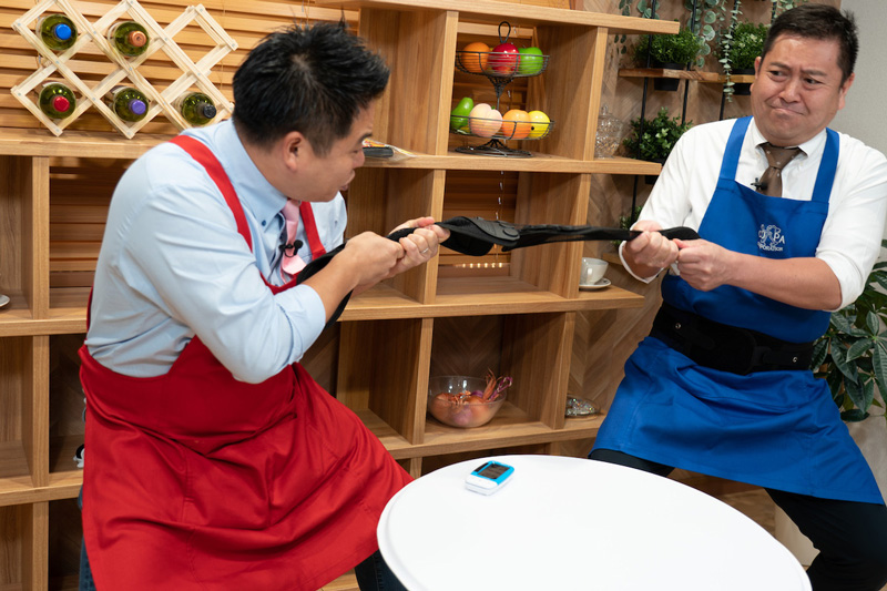 【写真】商品を両脇から2人で引っ張る